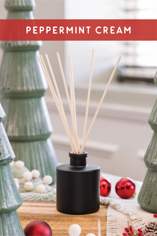 a bottle of peppermint cream next to a christmas tree