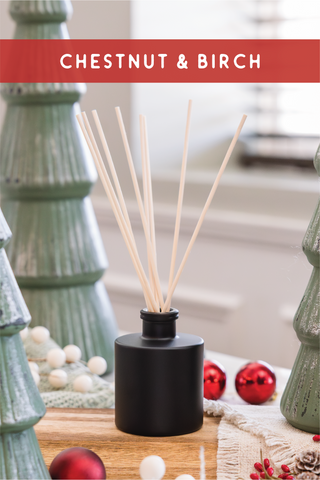 a wooden table topped with candles and christmas trees